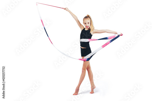 A girl athlete with white hair in a tracksuit stands with a gymnastic ribbon © Volodya
