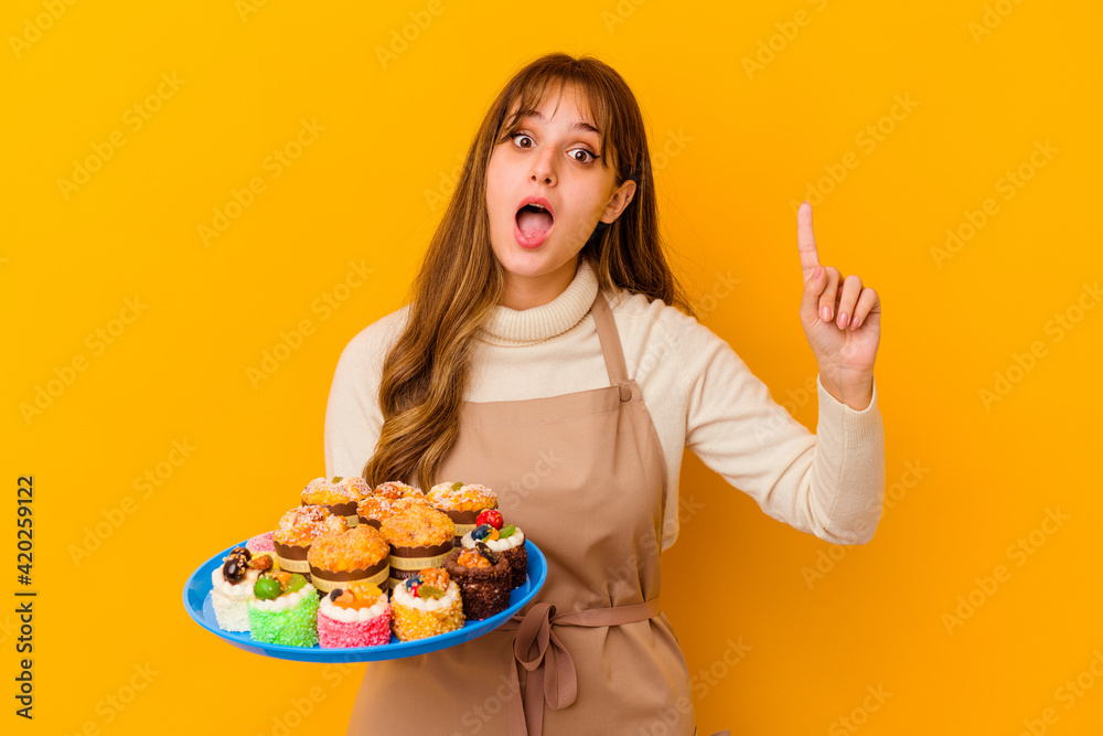 Young pastry chef woman isolated on yellow background having an idea, inspiration concept. Young pastry chef woman isolated on yellow background having an idea, inspiration concept.