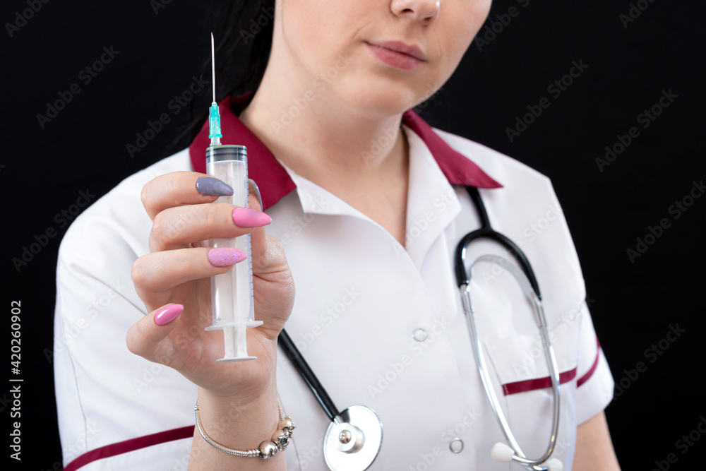 medicine, vaccination and healthcare concept, closeup of female doctor with stethoscope and syringe over dark background medicine, vaccination and healthcare concept, closeup of female doctor with stethoscope and syringe over dark background