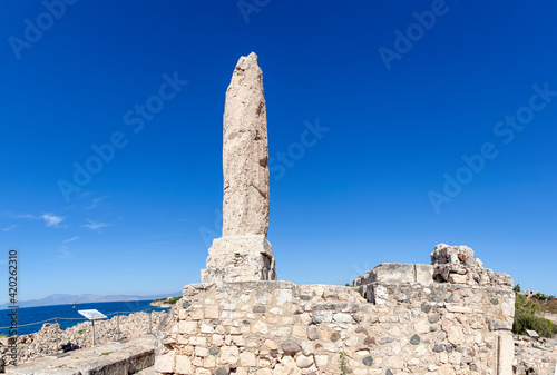 Ancient Egina island, view of the archaeological site of Kolona where remains a pillar of the archaic temple of Apolo, the ancient Greek god of light and music. In Egina island, Greece, Europe photo