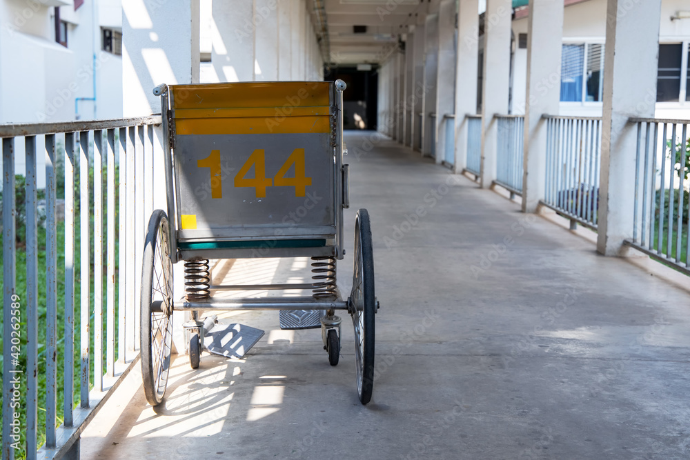 Empty wheelchair parked in hospital walk way or corridor.