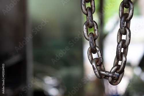 Old chains hanging on the ceiling with blurred background.