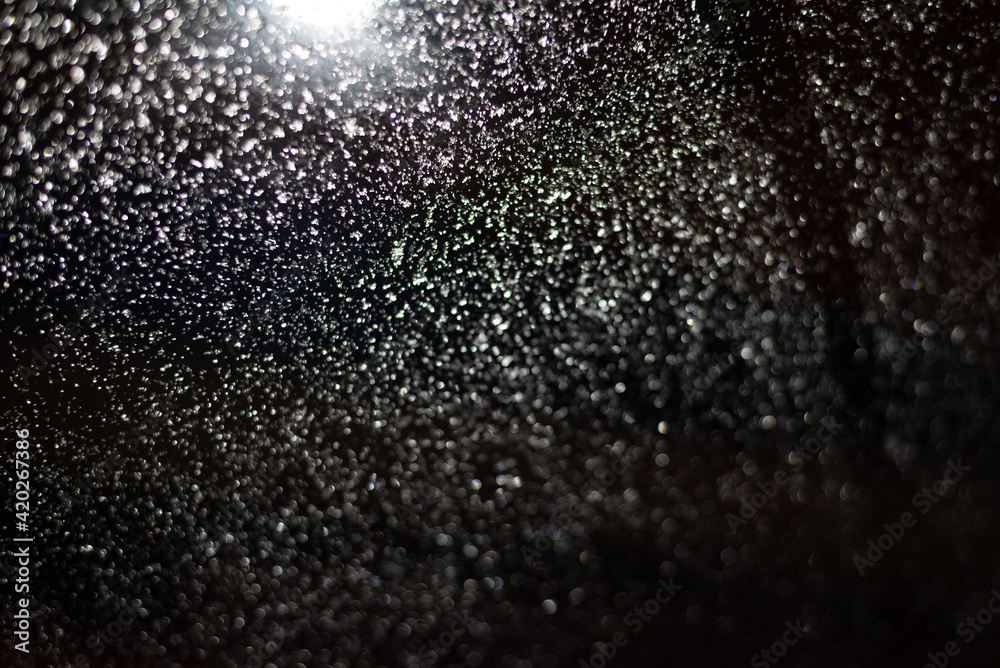 Obraz premium Blurred background with raindrops and lights.