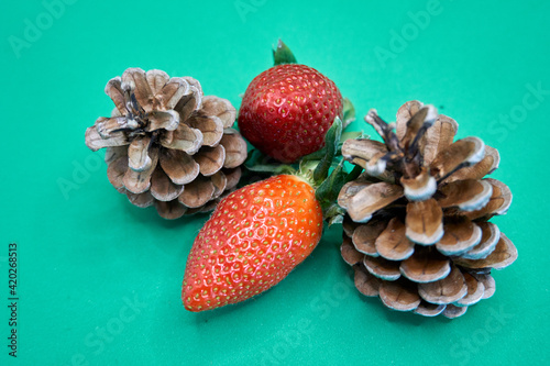 Close up of pine cones and strawberries with a turquoise background