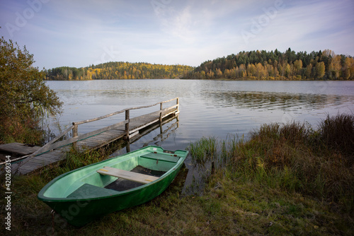 green boat on the lake shore on an autumn day