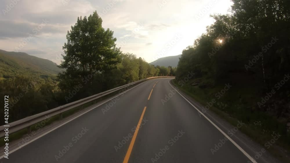Driving a Car on a Road in Norway at dawn Driving a Car on a Road in Norway at dawn