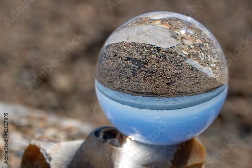 deserted beach reflected upside down in a crystal ball