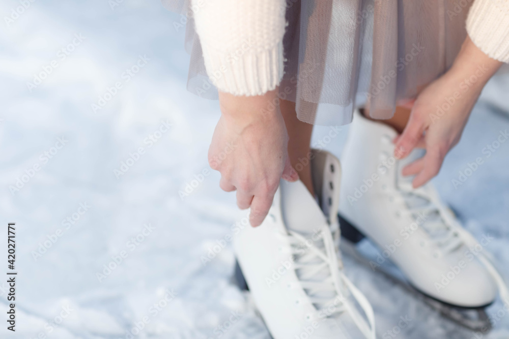 tying shoelaces on ice skates at the rink