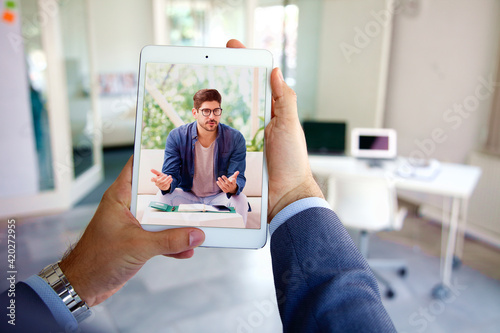 Rear view shot of businessman having online meeting in video call photo