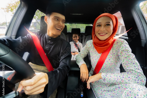 Malay family inside the car wearing traditional costume photo