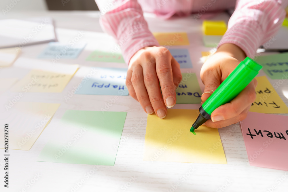 Business people write notes using stickers on paper. Brainstorming concept. Team meeting work on a project, develop ideas. Business people write notes using stickers on paper. Brainstorming concept. Team meeting work on a project, develop ideas.
