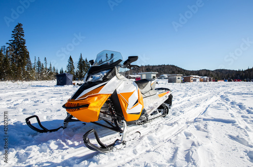 motoneige orange et blanche sur un lac glacé en hiver avec de la neig