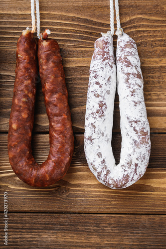 Traditional spanish smoked sausages meat hanging on wood table