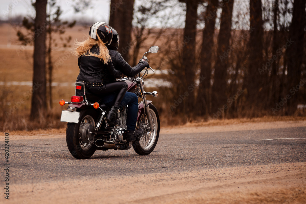 Bikers husband and wife riding a motorcycle on the road