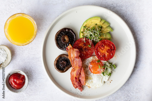 Fototapeta Naklejka Na Ścianę i Meble -  Breakfast with fried egg, tomatoes, mushroom, bacon and avocado