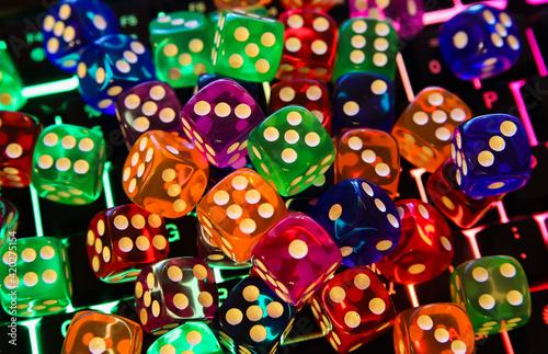 Makro closeup of many colorful bright shiny dices on illuminated computer keyboard