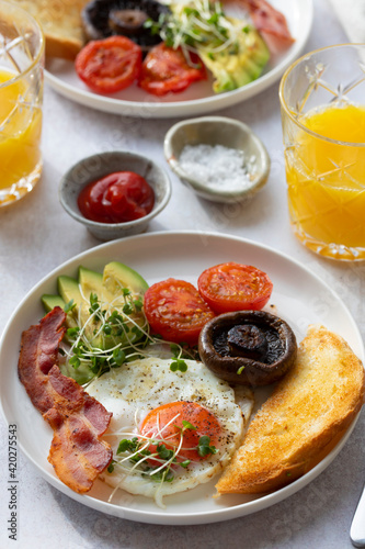 Breakfast with fried egg, tomatoes, mushroom, bacon and avocado