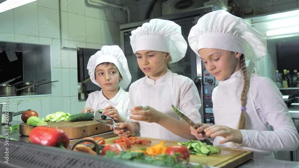 Healthy eating. Children cutting vegetable salad in the restaurant kitchen Healthy eating. Children cutting vegetable salad in the restaurant kitchen