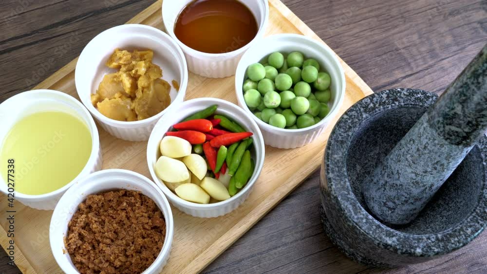 Top view of shrimp paste ingredient and stone mortar to make Spicy Shrimp Paste Chili Sauce, favorite Thai food (Nam Prik Ka Pi) Top view of shrimp paste ingredient and stone mortar to make Spicy Shrimp Paste Chili Sauce, favorite Thai food (Nam Prik Ka Pi)