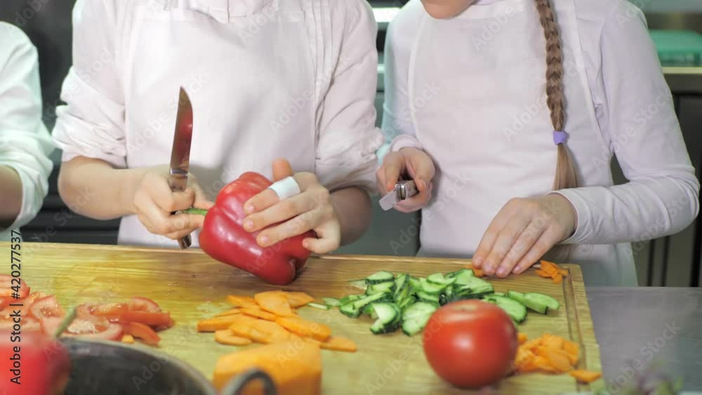 Healthy eating. Children cutting vegetable salad in the restaurant kitchen Healthy eating. Children cutting vegetable salad in the restaurant kitchen