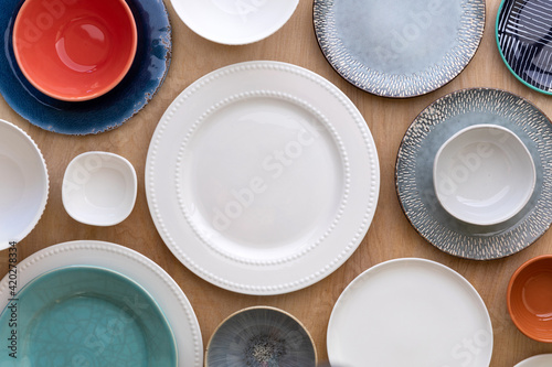 Top view of a table with many different empty plates, bowls and cups or glasses. Copy space in the middle.