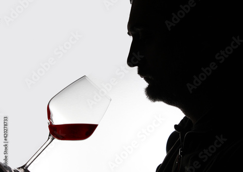 Fotografia silhouette of a sommelier tasting an excellent red wine