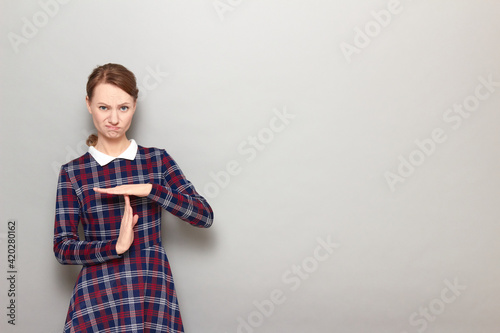 Portrait of perplexed unhappy girl showing timeout gesture with hands