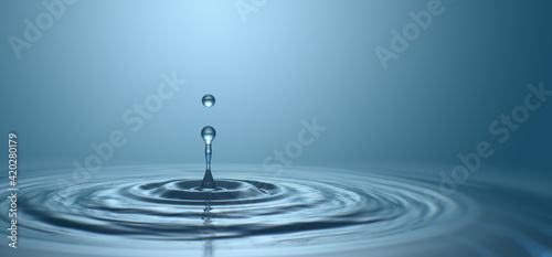 Water drop with droplet and rings on surface bluish background