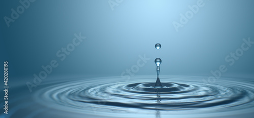 Water drop with droplet and rings on surface bluish background © willyam