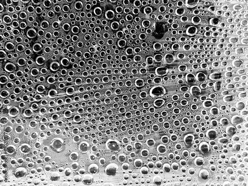 Abstract blurred background with water drops in black and white.  Water drops on glass.  Water and shadows texture.  The concept of cleanliness and freshness.