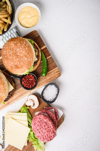 Burger with ingredients on white textured background, topview with space for text