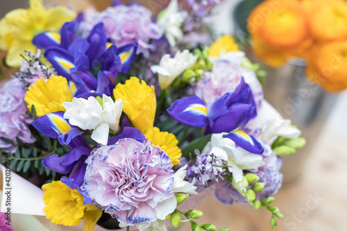 A chic multi-colored bouquet of flowering iris, cloves and hyacinth. Festive design of the windows of the floral store