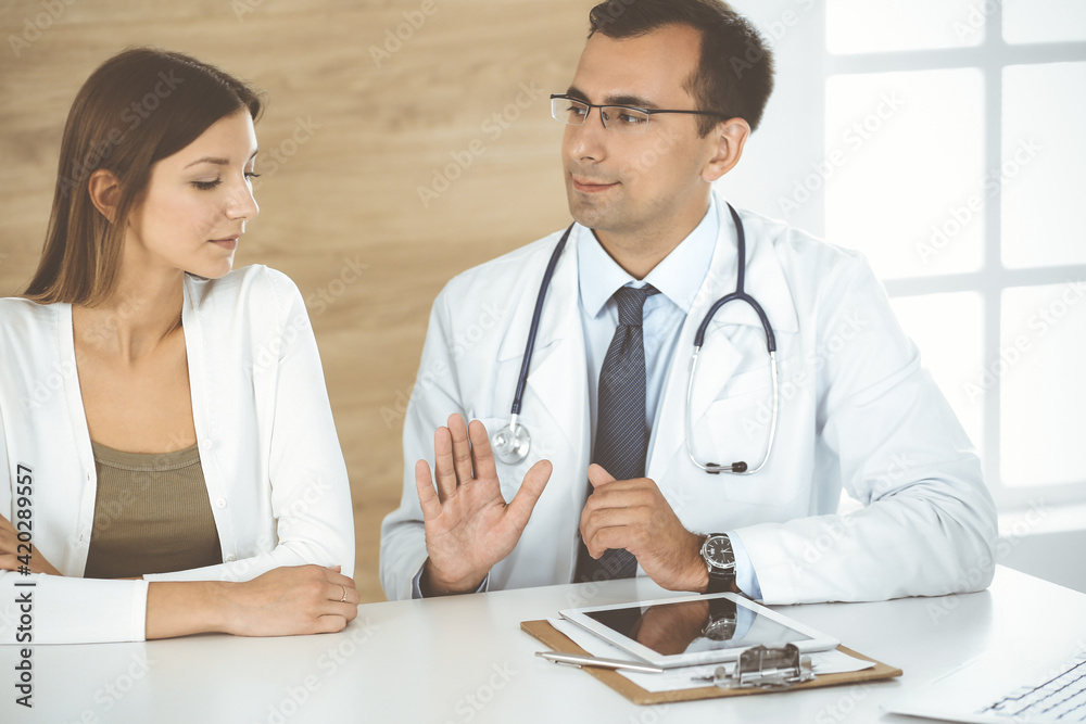 Doctor reassuring her female patient because of her first pregnancy fear in clinic. Concept of comforting, empathy and best medical service Doctor reassuring her female patient because of her first pregnancy fear in clinic. Concept of comforting, empathy and best medical service
