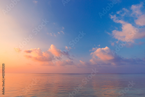 Sea ocean horizon. Skyscape with seascape. Orange and golden sunset sky, soft sand, calmness, tranquil relaxing sunlight, summer mood. Inspirational nature view, wide horizon of the sky and the sea