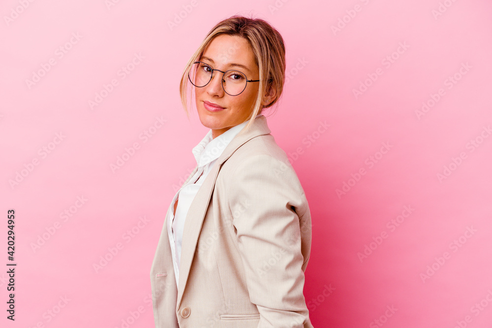 Young caucasian mixed race business woman isolated on pink background looks aside smiling, cheerful and pleasant. Young caucasian mixed race business woman isolated on pink background looks aside smiling, cheerful and pleasant.