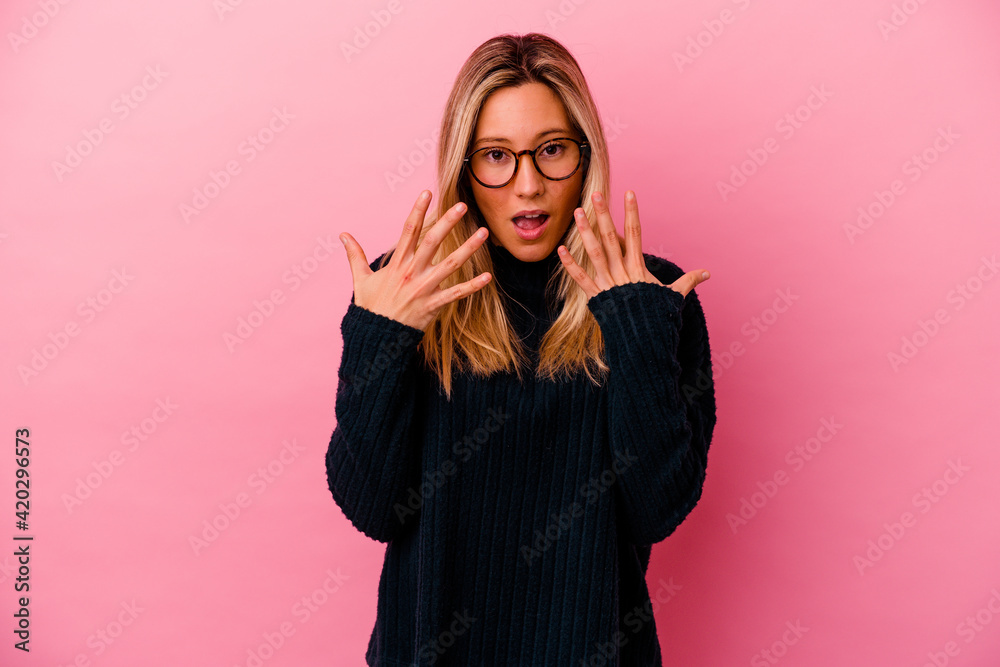 Young mixed race woman isolated on pink background showing number ten with hands. Young mixed race woman isolated on pink background showing number ten with hands.