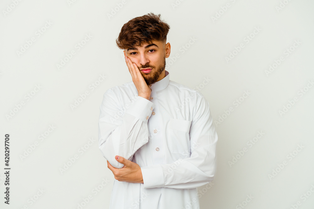 Young Moroccan man wearing a typical arab clothes isolated on white background who is bored, fatigued and need a relax day. Young Moroccan man wearing a typical arab clothes isolated on white background who is bored, fatigued and need a relax day.