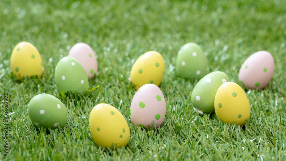Happy Easter. Pastel colored eggs on green grass, close up view Happy Easter. Pastel colored eggs on green grass, close up view