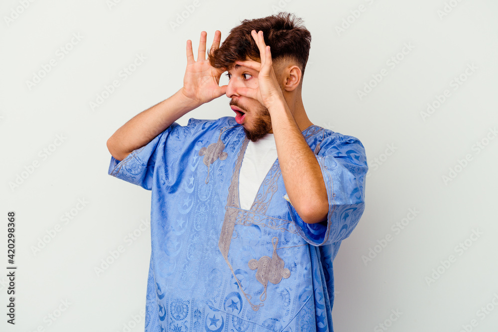 Young Moroccan man isolated on white background keeping eyes opened to find a success opportunity. Young Moroccan man isolated on white background keeping eyes opened to find a success opportunity.