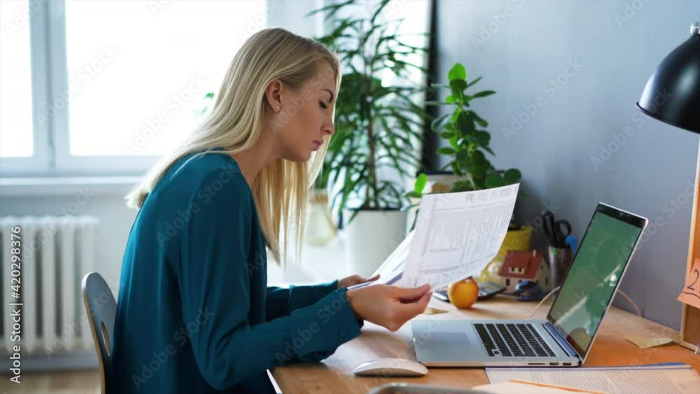 Young woman working at home browsing documents Young woman working at home browsing documents