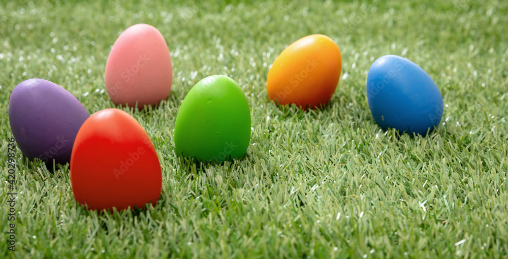Happy Easter. Colorful eggs on green grass, close up view