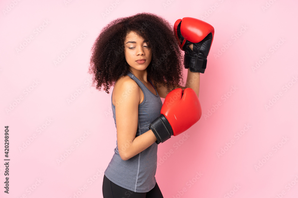 Young african american sport woman isolated on pink background with boxing gloves