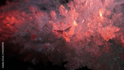 Macro photography of ice growths in a cave. Snow and ice of interesting shapes grow on the walls of the cave. Stalactites hang. Huge ice walls shimmer from the light of the lantern. Almaty, Kazakhstan photo