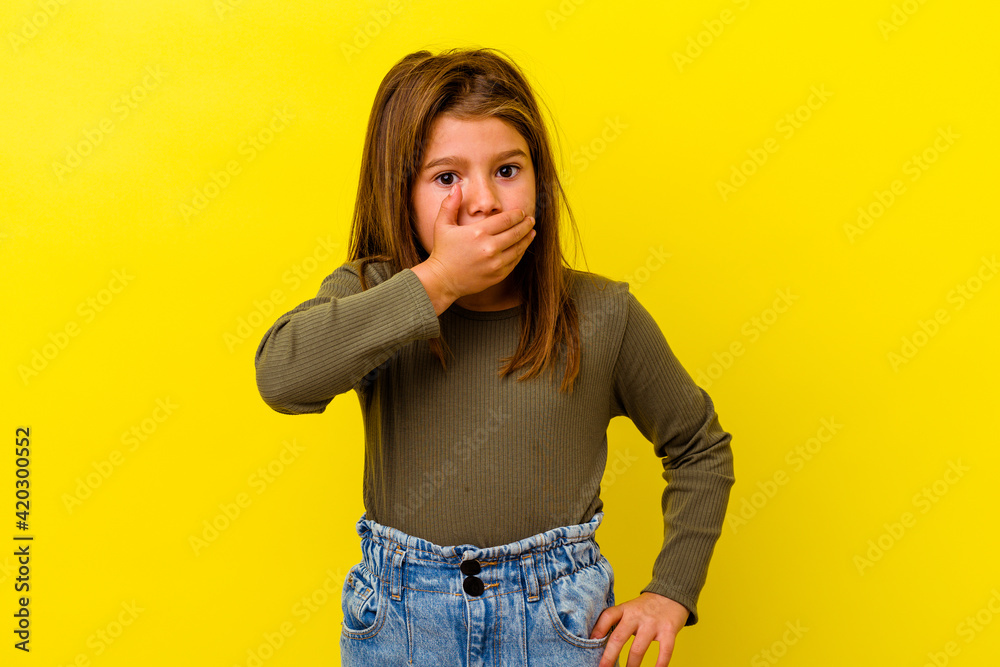 Little caucasian girl isolated on yellow background covering mouth with hands looking worried. Little caucasian girl isolated on yellow background covering mouth with hands looking worried.