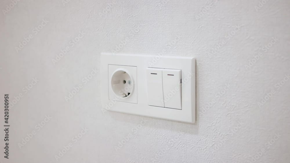 Hand pressing electronic-light switch. Close-up. Hand pressing electronic-light switch. Close-up.