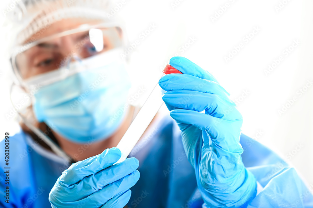 female doctor examines a test tube with tests. Medical concept. Blood tests and tests during the COVID 19 pandemic female doctor examines a test tube with tests. Medical concept. Blood tests and tests during the COVID 19 pandemic