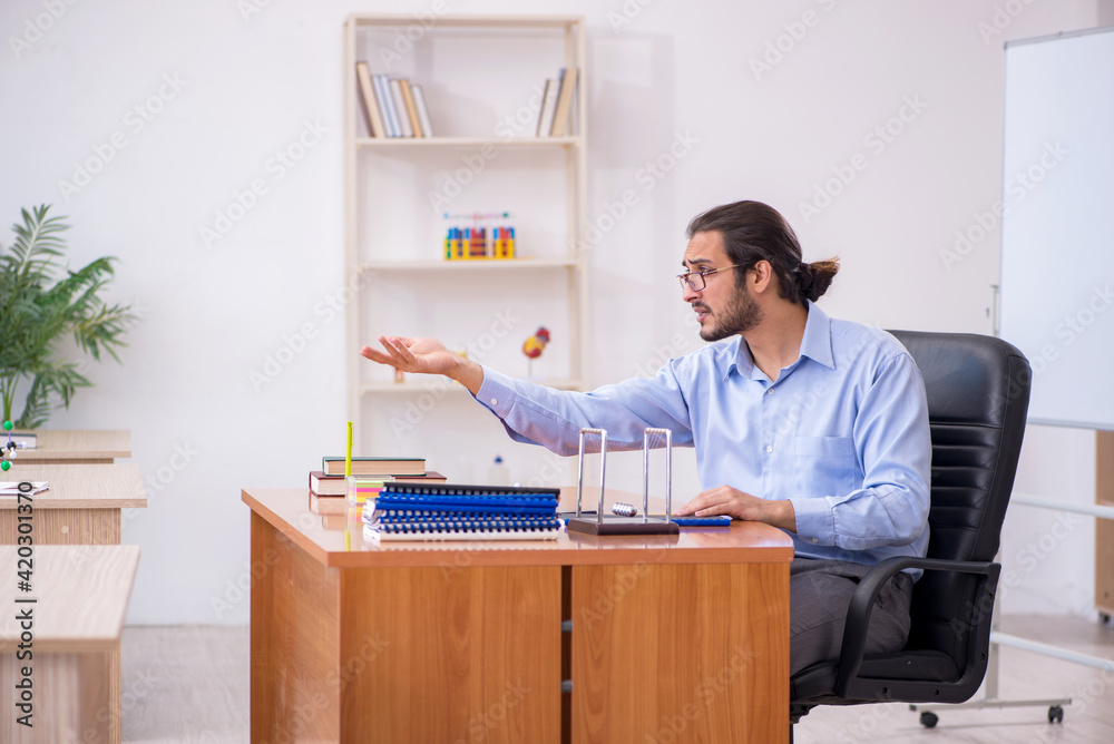 Young male teacher in the classroom during pandemic Young male teacher in the classroom during pandemic