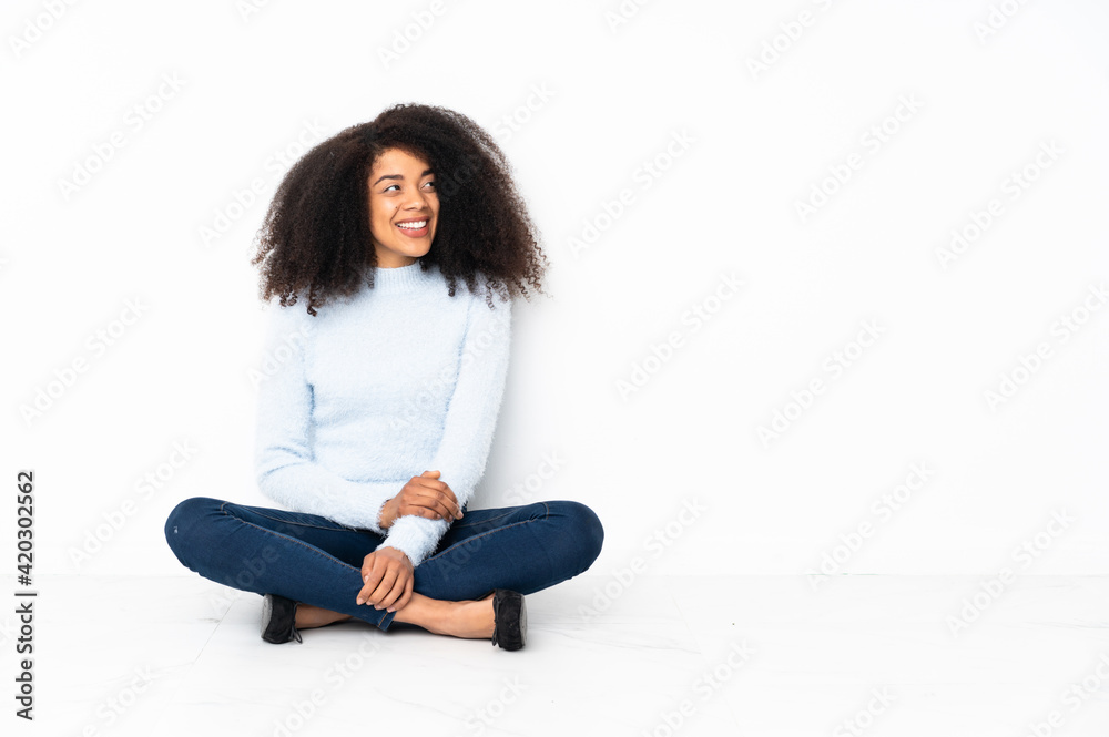 Young african american woman sitting on the floor laughing Young african american woman sitting on the floor laughing