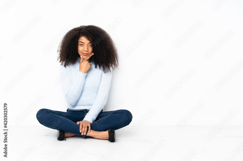 Young african american woman sitting on the floor thinking