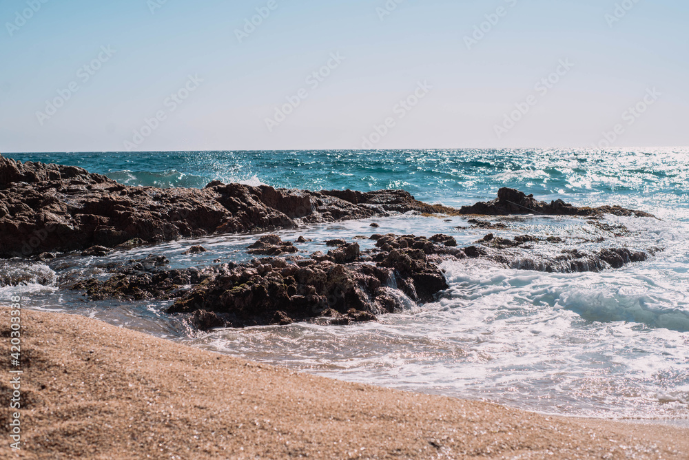 Una orilla con olas y espuma en la costa brava